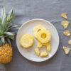 Plate of pineapple slices and dried pineapple on a table