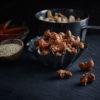 Siracha and sesame cashews in a bowl and a bowl of roasted cashews and chilies