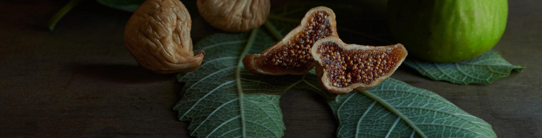 A cut open fig on a fig leaf
